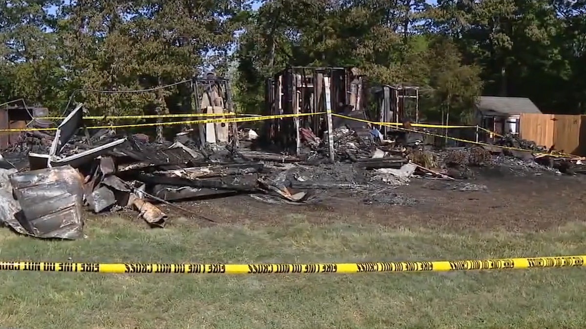 burnt and demolished house ruins with caution tape around