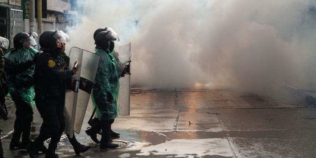 Riot police clash with anti-government protesters in Puno, Peru, on Jan. 9, 2023. At least 12 people died Monday in Peru as anti-government protesters trying to overrun an airport clashed with security forces, officials said.