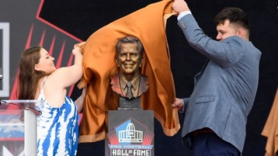 Art McNally's grandchildren unveil his bronze bust during the 2022 Pro Hall of Fame enshrinement ceremony in Canton, Ohio.