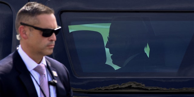 A Secret Service agent stands guard as President Biden sits inside the presidential SUV after arriving at Delaware National Guard Air Base on June 18, 2021, in New Castle, Delaware.