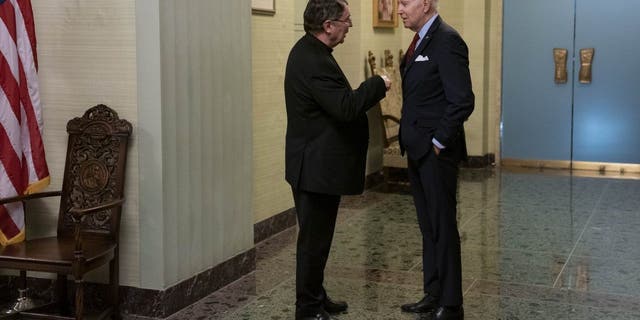 President Biden, right, speaks with Archbishop Christophe Pierre before signing the condolence book for Pope Emeritus Benedict XVI at the Apostolic Nunciature of the Holy See in Washington, D.C., Thursday, Jan. 5, 2023.