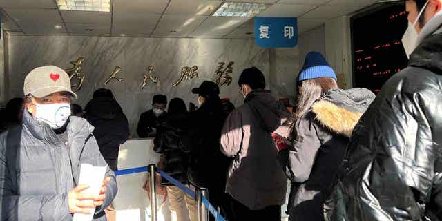 People line up at a government office that provides services, including making or renewing passports or permits to go to Hong Kong, Macau, and Taiwan, after China reopened its borders in Beijing, China, on Jan. 9, 2023. 