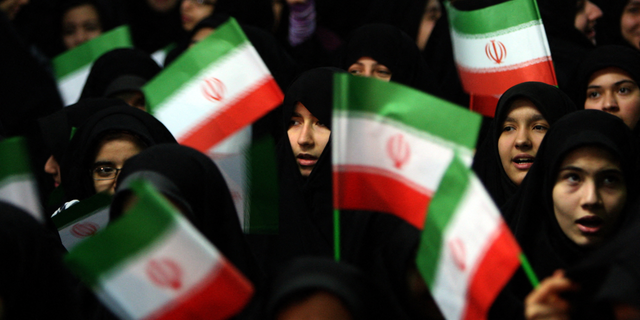 Schoolgirls wave Iranian flags during a ceremony marking the 33th anniversary of Ayatollah Ruhollah Khomeini's return from exile at Khomeini's mausoleum in Tehran.