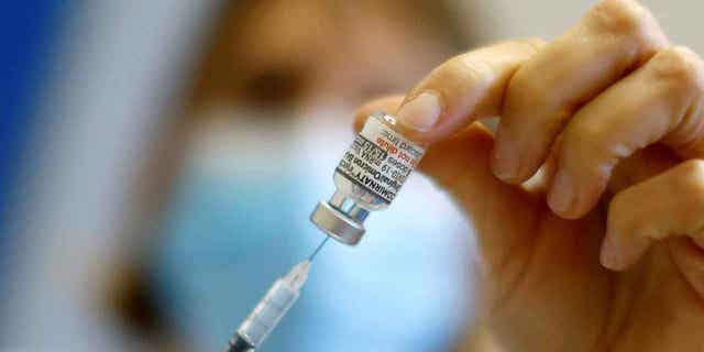 A medical worker prepares a dose of the Pfizer-Bivalent coronavirus vaccine at a vaccination center in Nice, France, on Dec. 7, 2022. The EU is working on paying more in exchange for a lower volume of Pfizer vaccines after agreeing to buy half a billion doses earlier in the year.