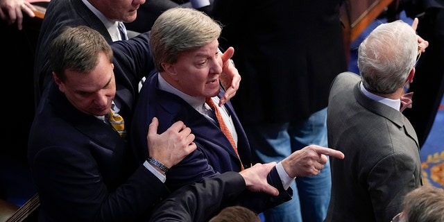 Rep. Richard Hudson, R-N.C., left, pulls Rep. Mike Rogers, R-Ala., back as they talk with Rep. Matt Gaetz, R-Fla., and other during the 14th round of voting for speaker as the House meets for the fourth day to try and elect a speaker and convene the 118th Congress in Washington, Friday, Jan. 6, 2023. 