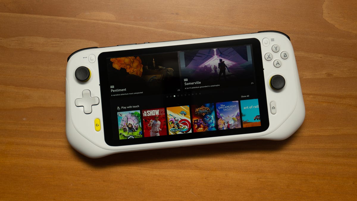 Logitech G Cloud lying on a wood table with Xbox Cloud Gaming thumbnails on the screen