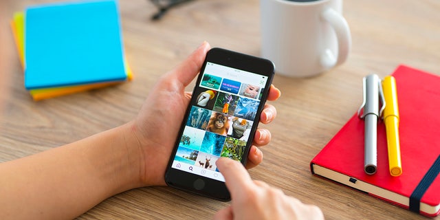 A woman using a smartphone at a desk.