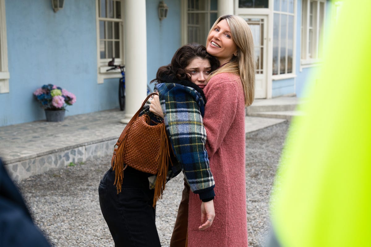 An older sister holding up her younger drunk sister outside her house