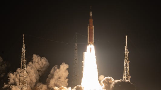 Artemis I rocket takes off in the dark with engines blazing.