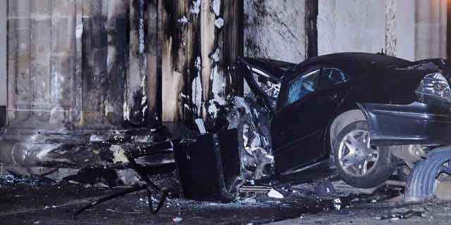 A destroyed car lies between two pillars of the Brandenburg Gate in Berlin, Germany, on Jan. 16, 2023. The driver of the car died in the accident.
