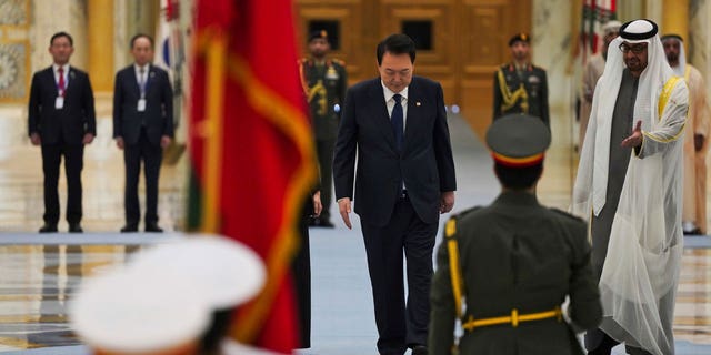 South Korean President Yoon Suk Yeol, center, and Emirati leader Sheikh Mohammed bin Zayed Al Nahyan, right, attend a ceremony at Qasar Al Watan in Abu Dhabi, United Arab Emirates, Sunday, Jan. 15, 2023. Yoon received an honor guard welcome Sunday on a trip to the United Arab Emirates, where Seoul hopes to expand its military sales while finishing its construction of the Arabian Peninsula's first nuclear power plant. (AP Photo/Jon Gambrell)