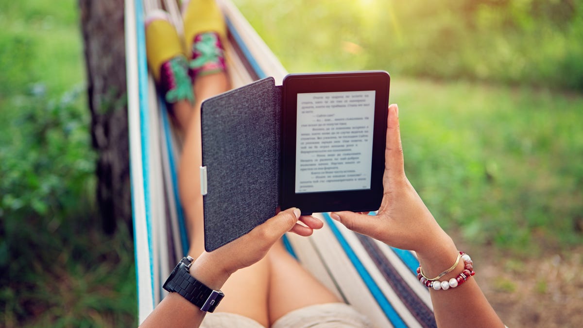 Person in a hammock reading from a tablet