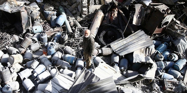 A man stands on the rubble of damaged buildings after an airstrike on the rebel-held town of Mesraba in the eastern Damascus suburb of Ghouta, Syria, November 26, 2017.