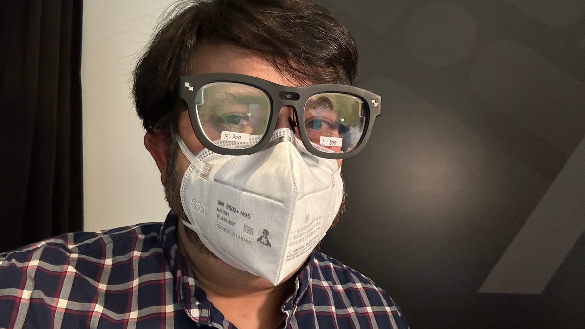 A man wearing an N95 mask and a pair of large black AR glasses