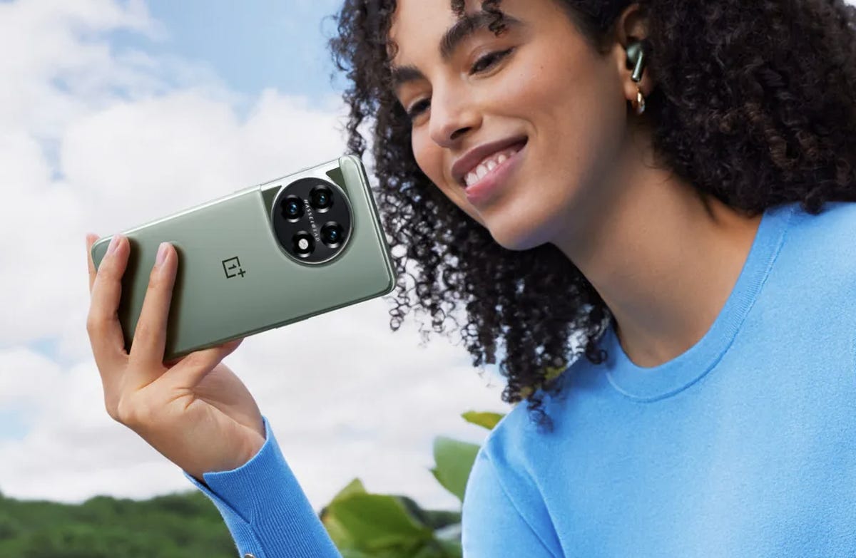 A woman holding the OnePlus 11 5G phone