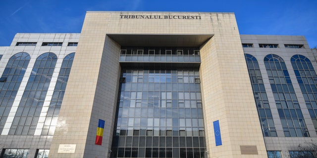 People walk outside the Bucharest Court where a judge extended the initial detention period of 24 hours, for Andrew Tate and his brother Tristan, to 30 days in Bucharest, Romania, Friday, Dec. 30, 2022.