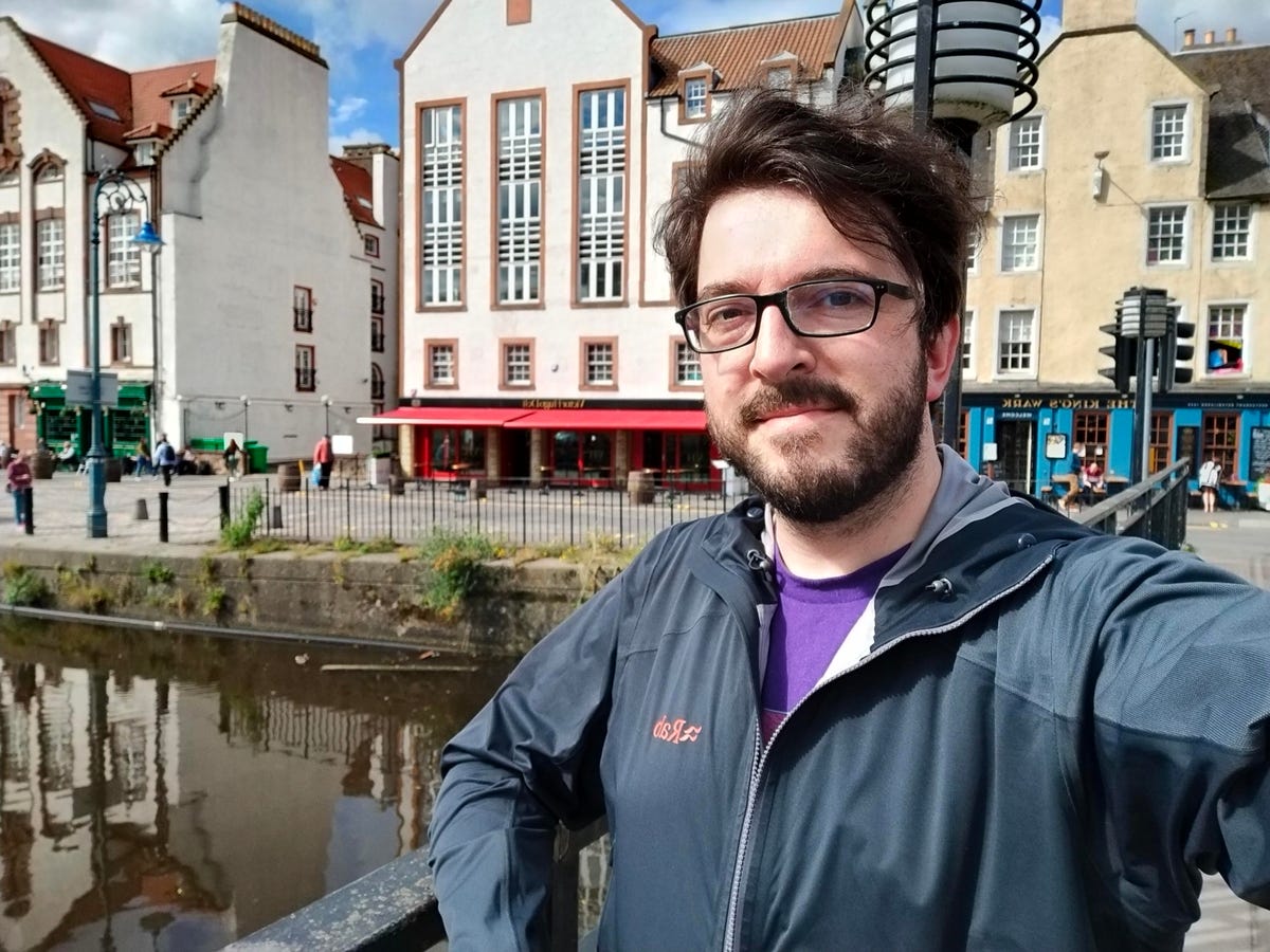Selfie in front of buildings by a river