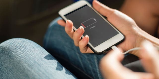 Person holding phone with low battery