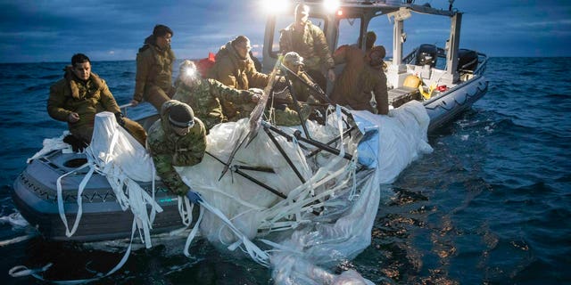 U.S. forces haul debris from China's surveillance balloon onto a boat off the coast of South Carolina.