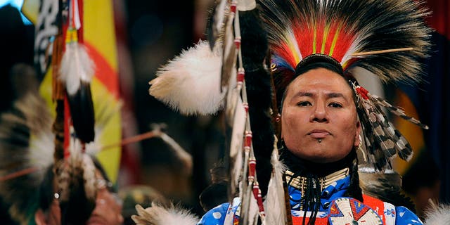 Nathan Chasing Horse of Rosebud, South Dakota, and a member of the Sioux Tribe, leads the Color guard at the beginning of the grand entry into the coliseum.