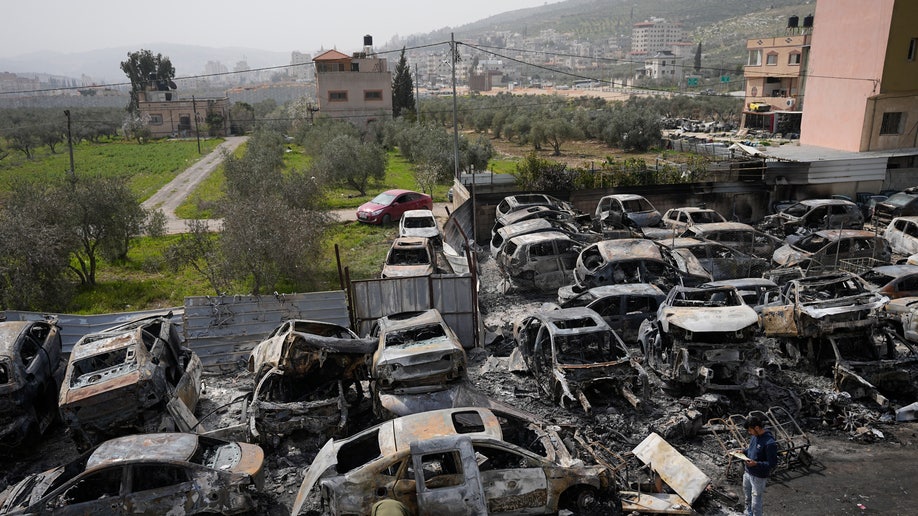 scorched cars in a scrapyard