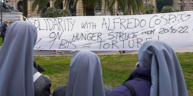 Three nuns watch at a banner in solidarity with Alfredo Cospito being displayed in front of the Italian Cassation Court in Rome, on Feb. 24, 2023, while the case of anarchist Alfredo Cospito, who has been on a hunger strike since October to protest a strict prison regime reserved for terrorists and mafiosi, is being discussed.