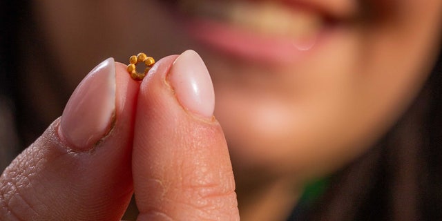 Hallel Feidman with the rare gold bead on Feb. 8, 2023. The gold bead was discovered in Israel Antiquities Authority excavations in the City of David.