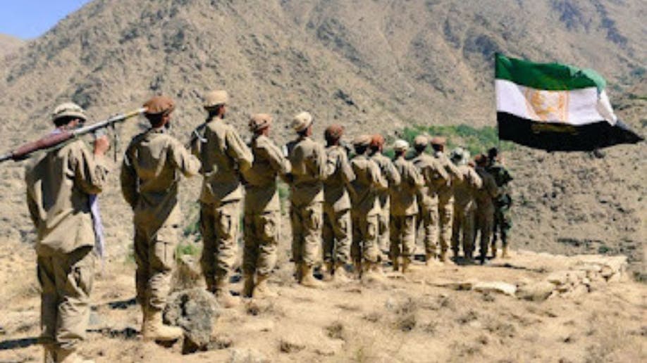 NRF fighters stand behind the flag representing the National Resistance Front of Afghanistan