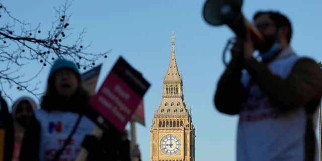 A protestor with a megaphone shouts slogans in front of Big Ben as nurses of the nearby St. Thomas' Hospital protest in London, England, on Feb. 6, 2023.