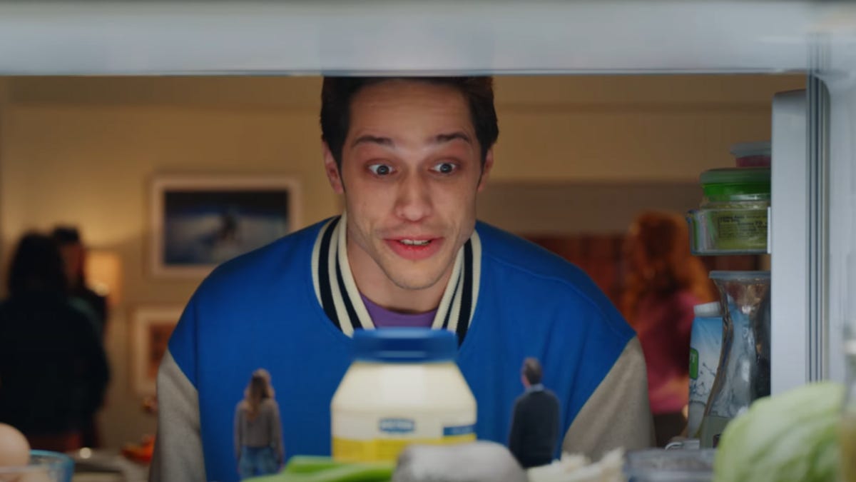 Pete Davidson looks into a refrigerator.