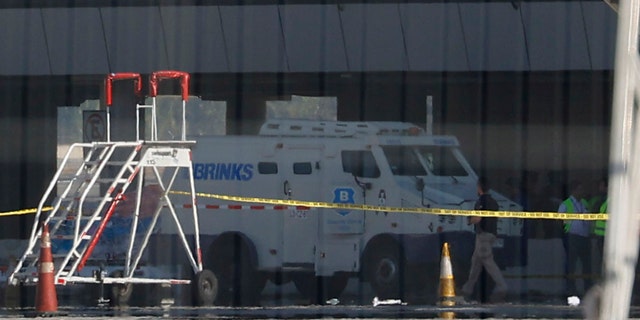 An armored truck is surrounded by police tape at the Arturo Merino Benitez International Airport in Santiago, Chile, Wednesday, March, 8, 2023. An airport shootout killed a security officer and an alleged robber, authorities say.