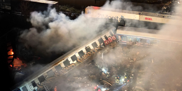 Smoke rises from trains as firefighters and rescuers operate after a collision near Larissa city, Greece.