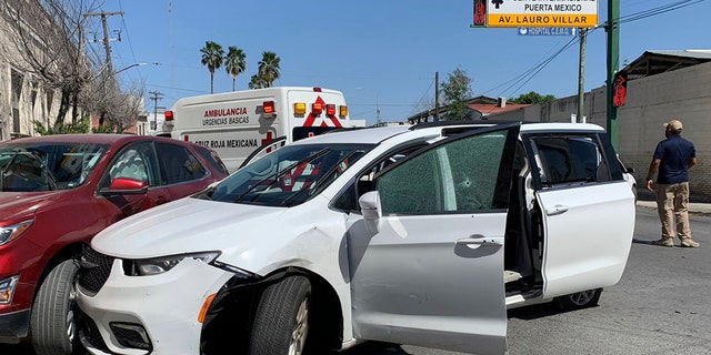 A member of the Mexican security forces stands next to a white minivan with North Carolina plates and several bullet holes, at the crime scene where gunmen kidnapped four U.S. citizens who crossed into Mexico from Texas, Friday, March 3, 2023.