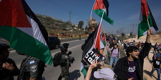 Israeli border police officers block hundreds of Israeli left-wing activists from staging a solidarity rally on March 3, 2023, in a Palestinian town that was set ablaze by radical Jewish settlers Sunday.