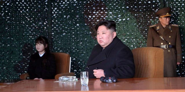 North Korean leader Kim Jong Un, with his daughter, inspects what it says is an artillery drill at an undisclosed location in North Korea, Thursday, March 9, 2023.