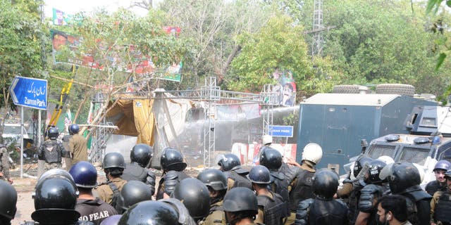 Pakistani security forces clash with supporters of former Prime Minister Imran Khan outside his residence to prevent his possible arrest in Lahore, Pakistan, on March 15, 2023.