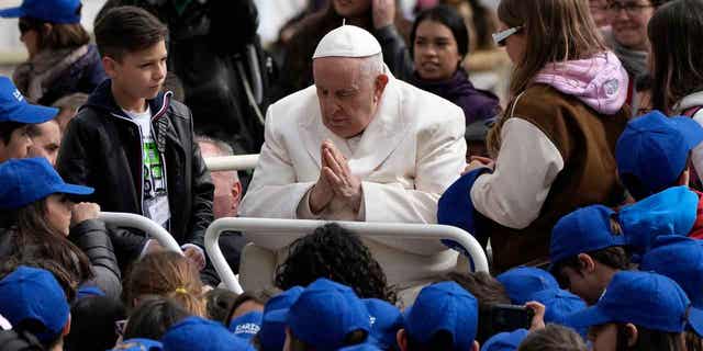 Pope Francis meets children in St. Peters Square, at the Vatican, on March 29, 2023. Francis is being discharged from the hospital where he's being treated for bronchitis.