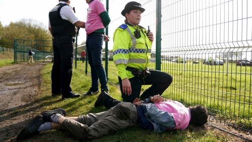 Protesters are detained by police on April 15. 