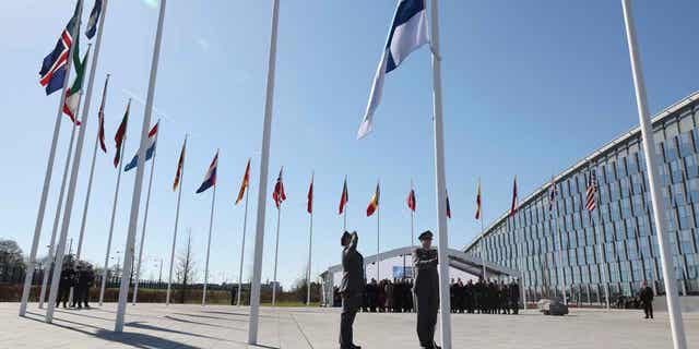 Military personnel raise the flag of Finland during a flag raising ceremony on the sidelines of a foreign ministers meeting at NATO headquarters in Brussels.