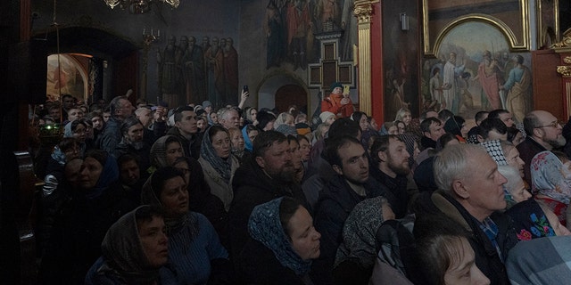 People gather to pray in the Kyiv Pechersk Lavra monastery complex in Kyiv, Ukraine, Wednesday, March 29, 2023.  