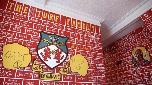 Ryan Reynolds and Rob McElhenney autographs can be seen on a wall at the Turf.