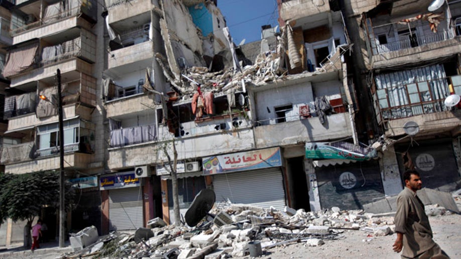 A Syrian man walks by a building destroyed in an airstrike in Aleppo city, Syria, Friday, Aug. 17, 2012. Rebel footholds in Aleppo have been the target of weeks of Syrian shelling and air attacks as part of wider offensives by President Bashar Assad's regime. Rebels have been driven from some areas, but the report of clashes near the airport suggests the battles could be shifting to new fronts. (AP Photo/Khalil Hamra)