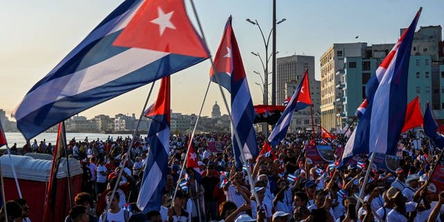 Demonstrators wave Cuban flags