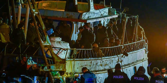 Migrants on fishing boat at Italian port