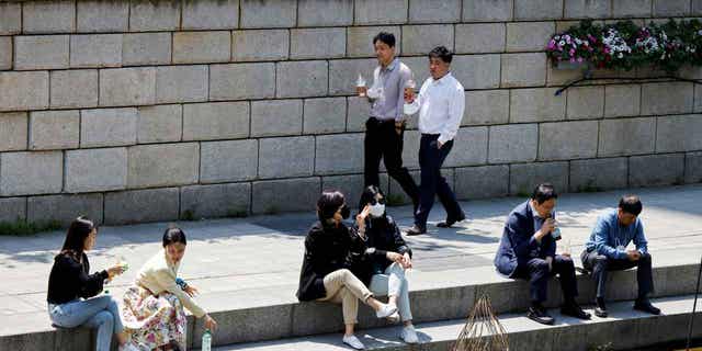People walk on a sunny spring day in Seoul