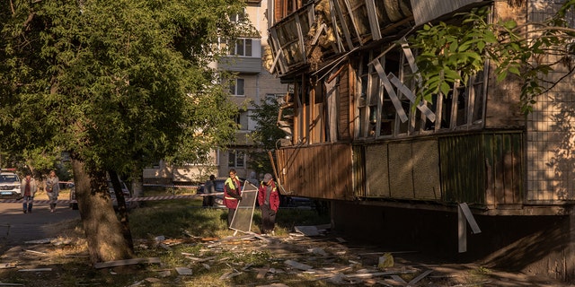 People clean debris from attack