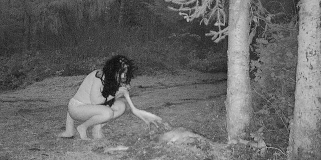 woman holding dead deer hoof