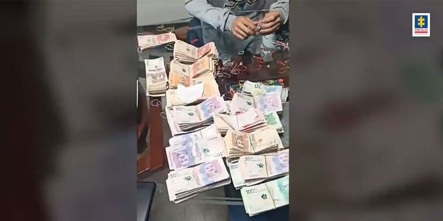 Stacks of money on a table that were seized in a raid in Colombia.