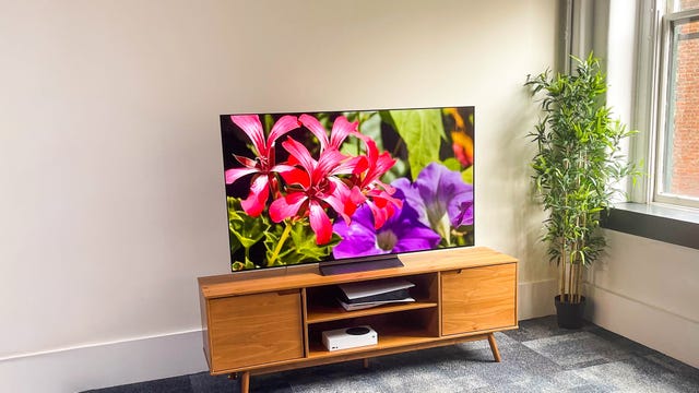 LG C2 OLED TV in a bright room on a wooden TV stand