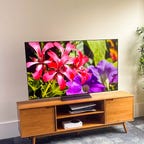 LG C2 OLED TV in a bright room on a wooden TV stand
